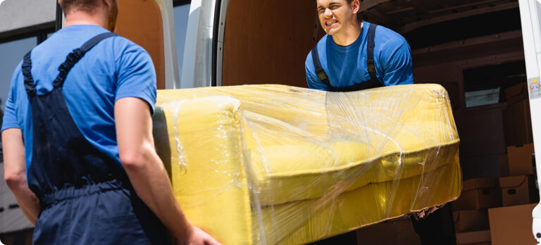selective-focus-movers-unloading-sofa-stretch-wrap-truck-outdoors